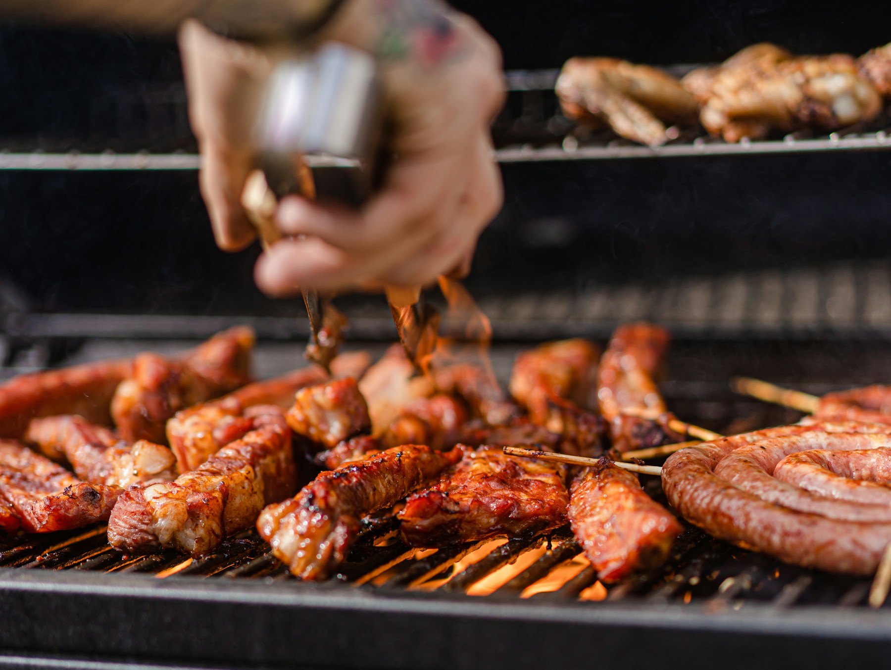 Grill tools in use over charcoal